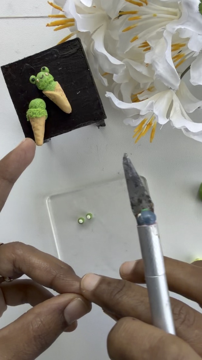Painting the eyes on a clay ice-cream miniature